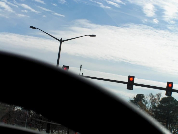 a red light sitting next to a street light