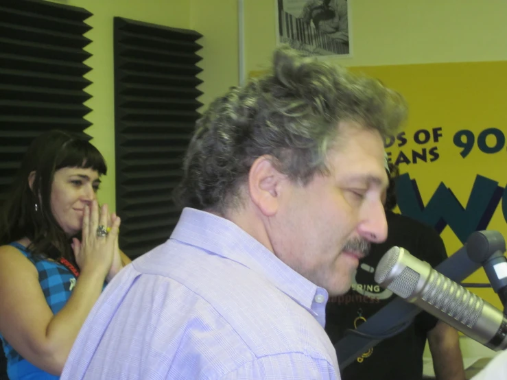 man with gray hair singing into a microphone