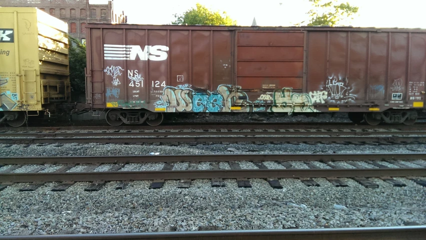 a train with graffiti sits on tracks