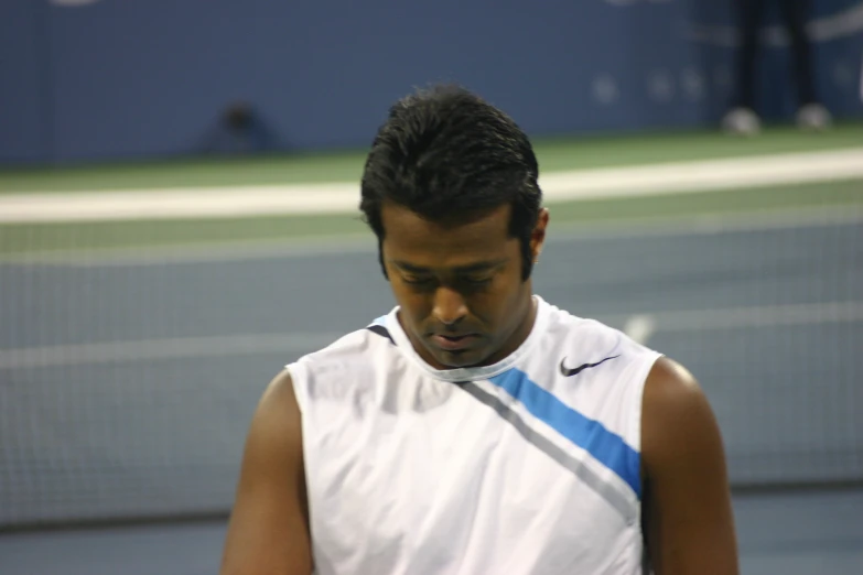there is a tennis player on the court, looking down at his head