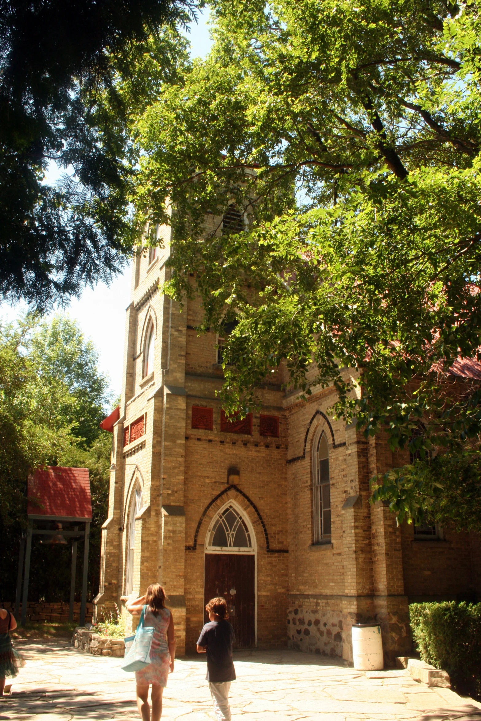 an old stone church with two people walking by