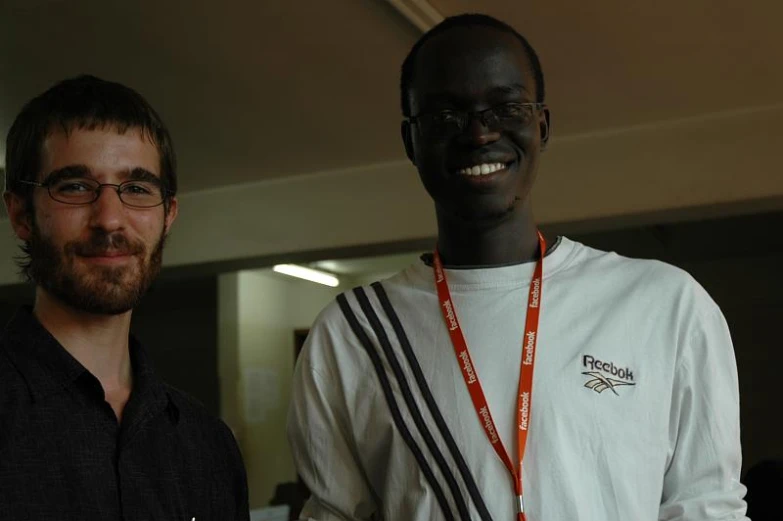 two men smile for the camera with medals on