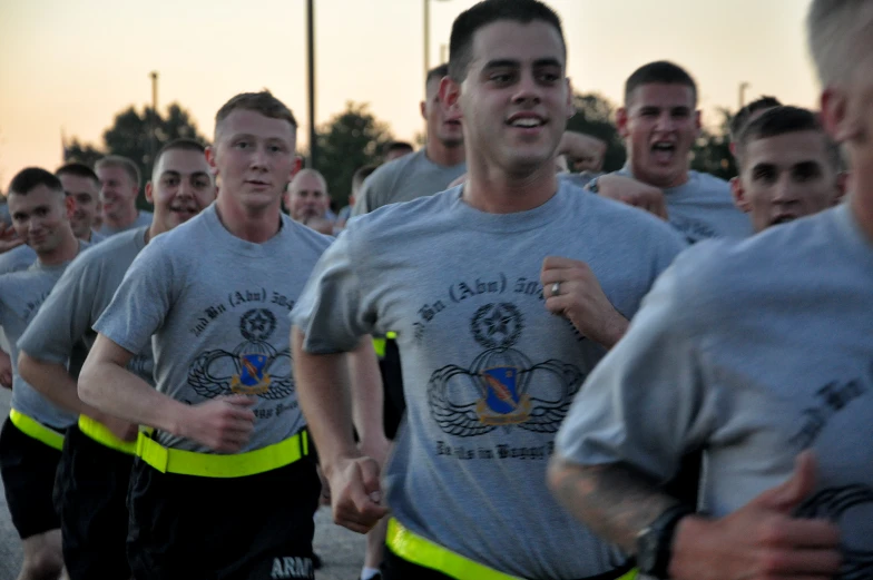 a group of people in grey and yellow shirts running