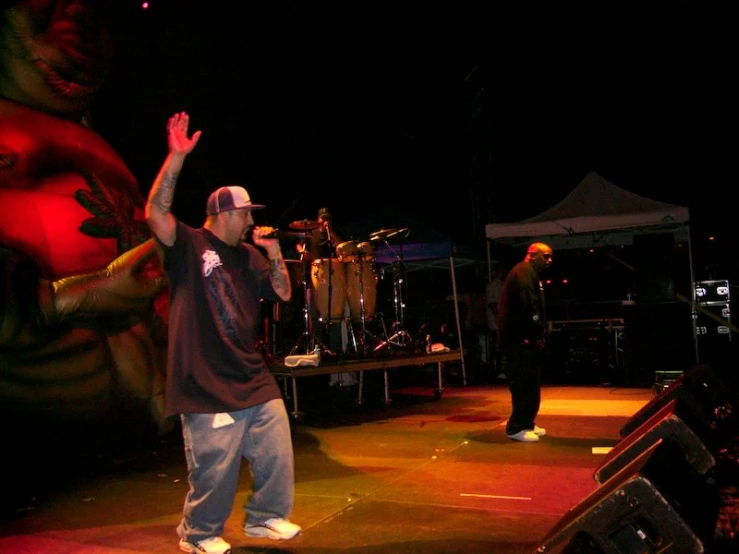 two men on stage holding hands up with one raising his hands