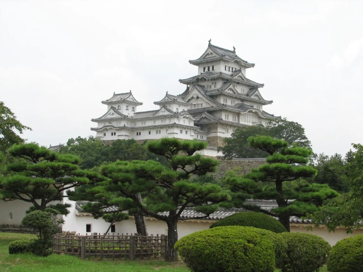 a white palace on a hilltop surrounded by evergreens