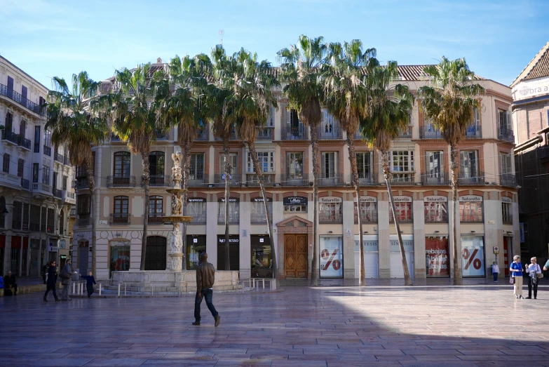 a large building with many windows and lots of palm trees