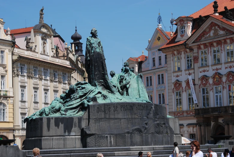 statue on the corner of a square with buildings behind it