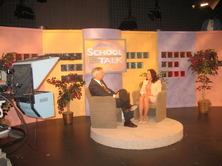 two people talking on a stage in a show