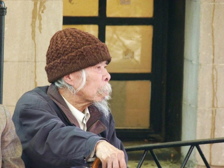 an elderly man with white beard sitting next to another older man with gray hair