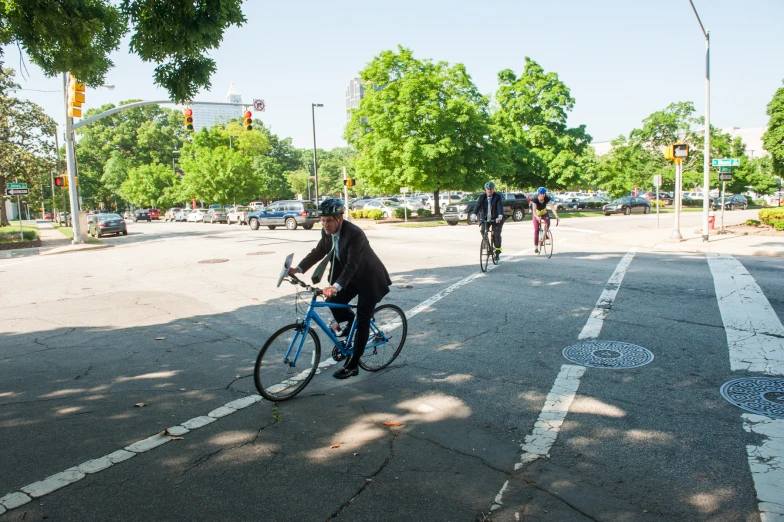 a guy on a bike crossing the street at an intersection