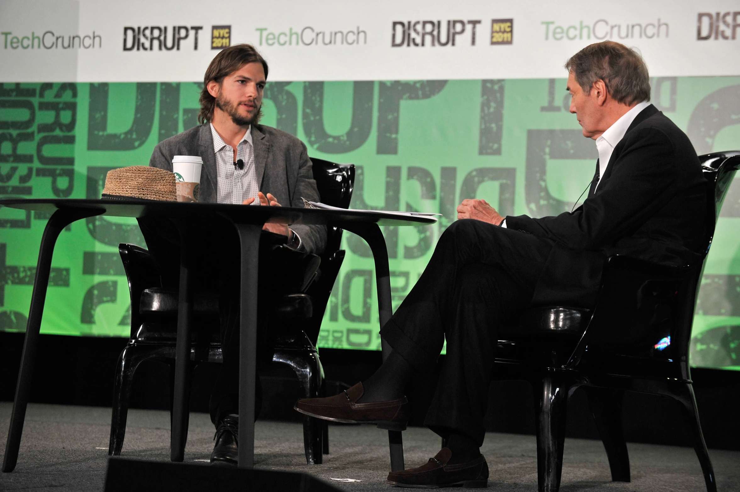 the two men are talking to each other at a conference