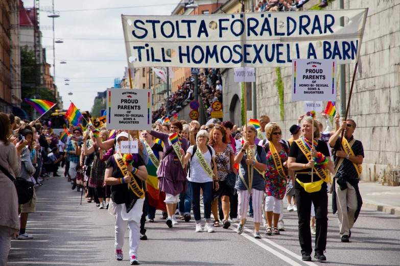 group of people carrying signs while marching down the street