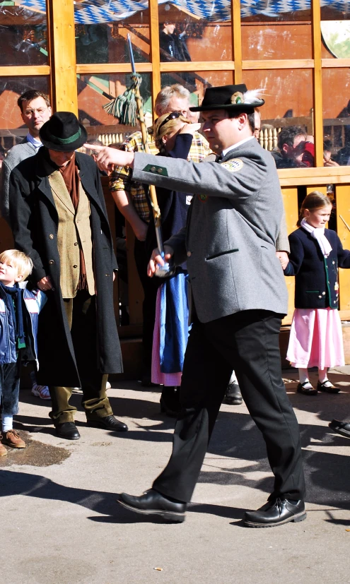 several people dressed in black suits and hat playing violin