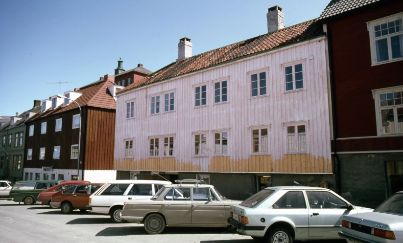several cars parked along the side of a building