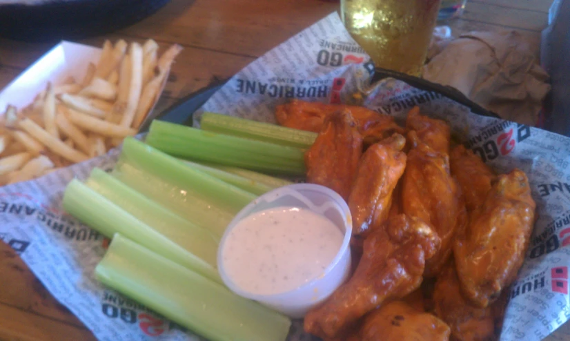 a tray topped with chicken wings and celery