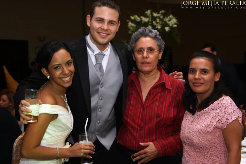 a man standing next to two women while posing for the camera