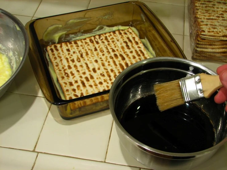 a pan filled with a lot of food sitting next to a brush