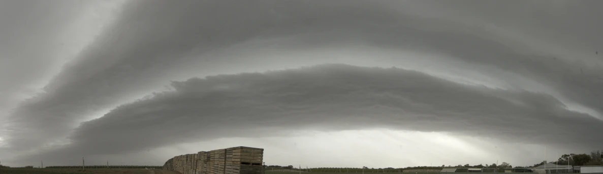 a large, dark and ominous looking cloud hangs above an abandoned building