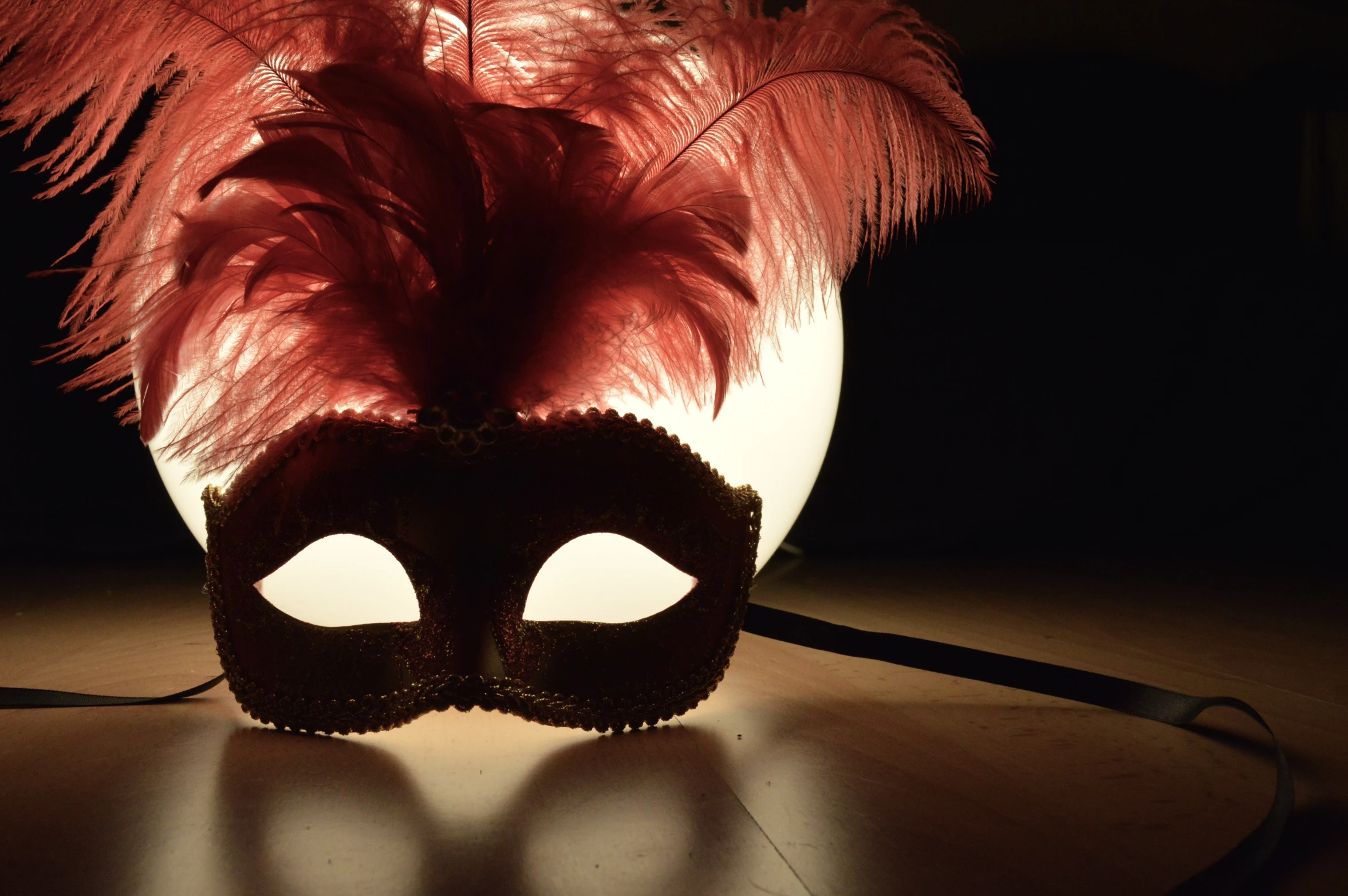 a mask with feathers on a table