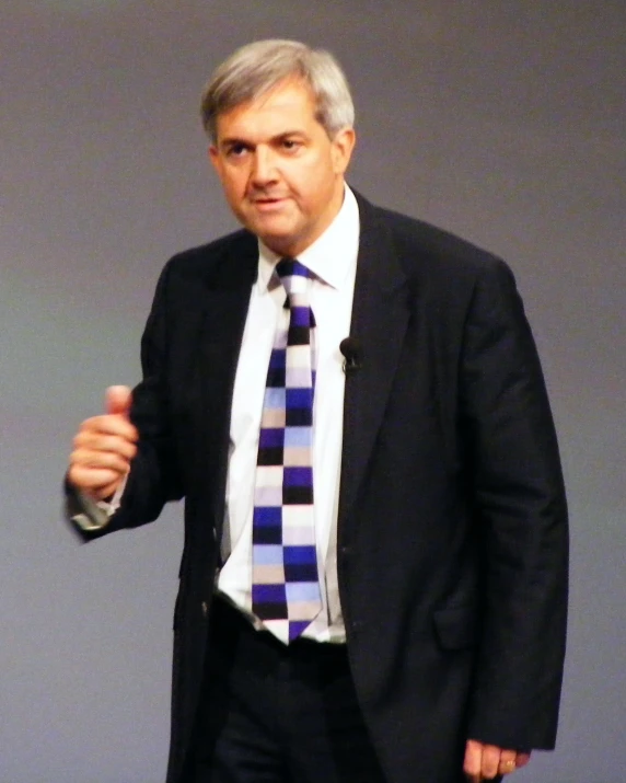 a man in a suit and tie is giving a speech