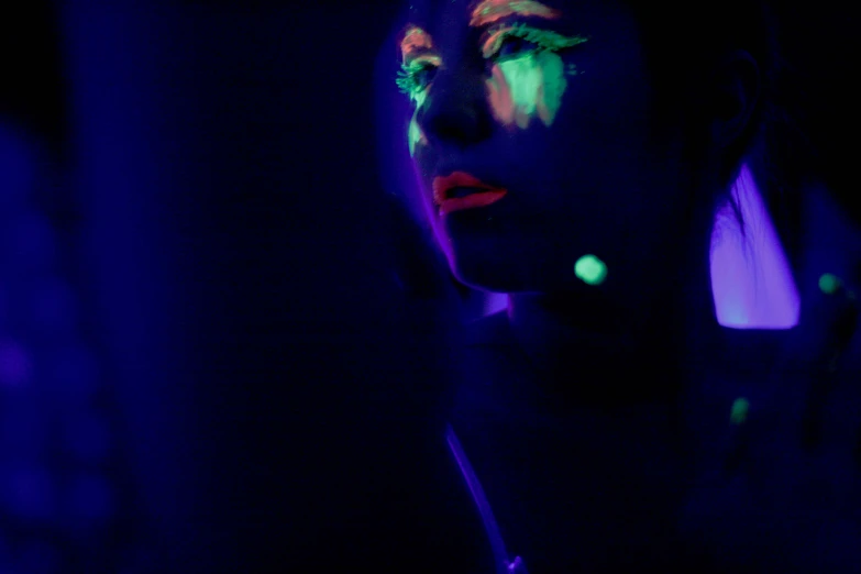 a woman has glow paint all over her face