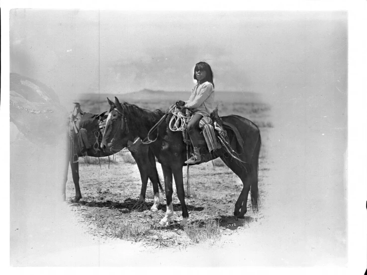 two young women riding horses in a field