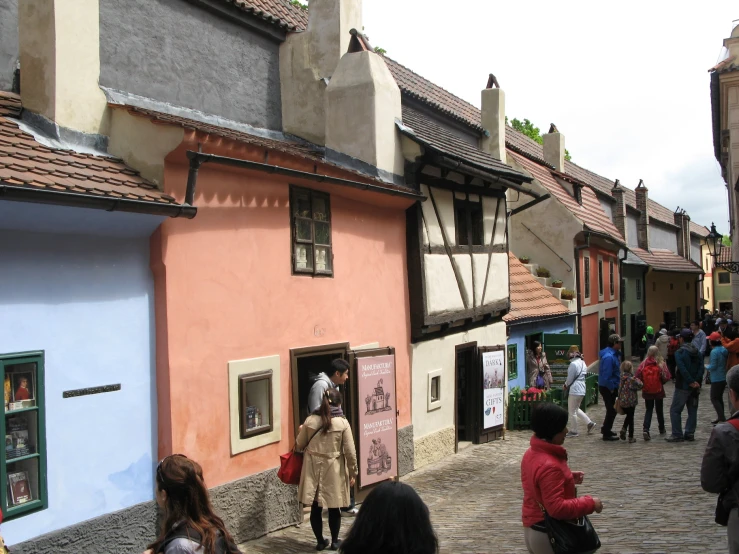 many people walking around in front of colorful buildings