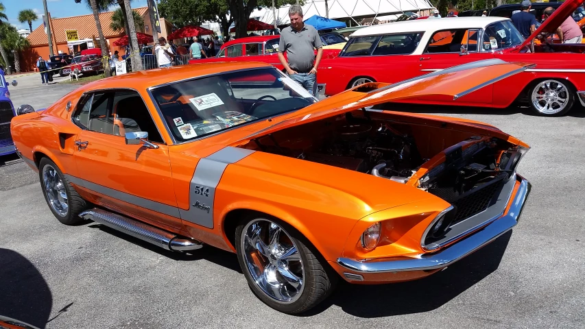 the orange mustang muscle is parked in the parking lot