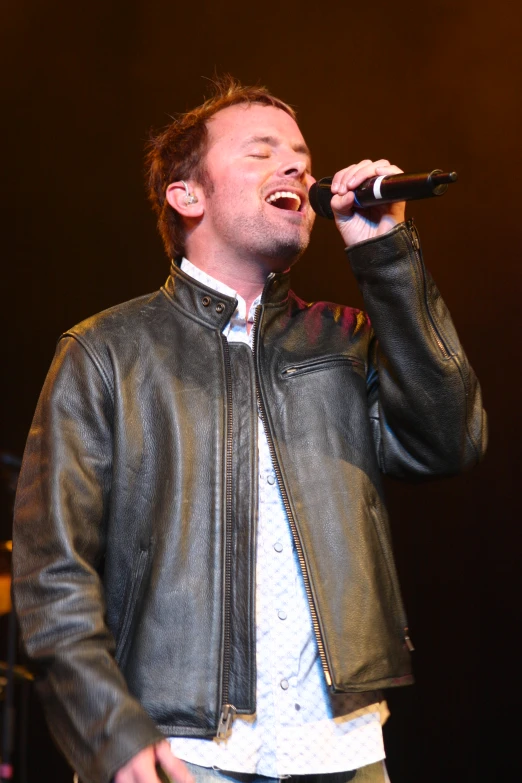 a man standing next to a microphone on stage