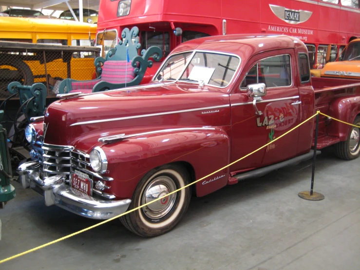 red pickup truck in show room near yellow double decker bus