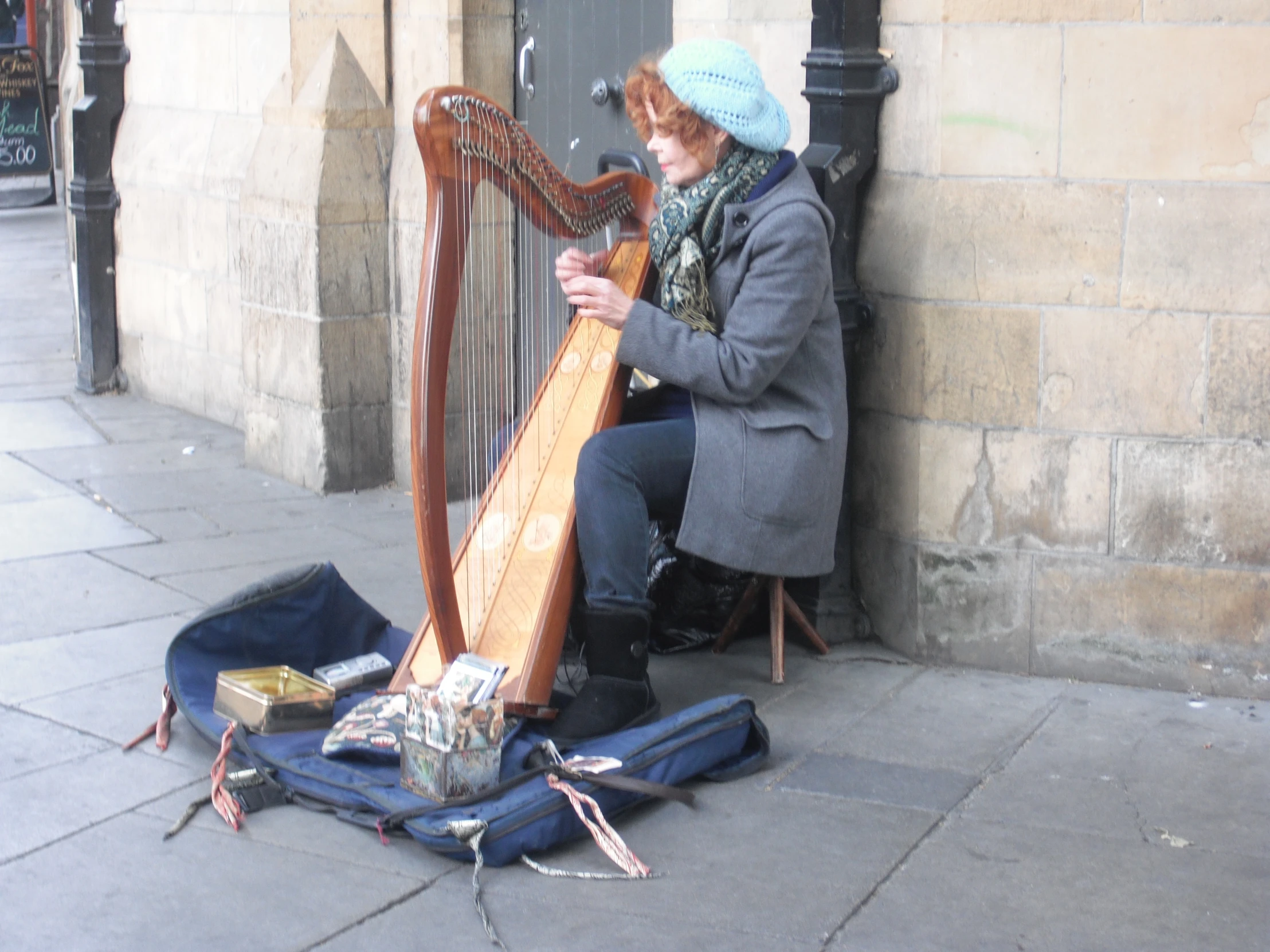a woman plays an instrument near a building