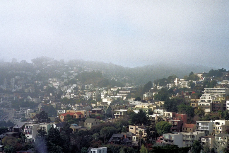 a village nestled in the hills with a gray sky