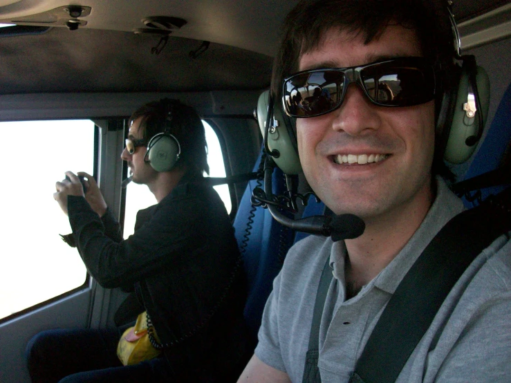 two people with head phones riding in a jet