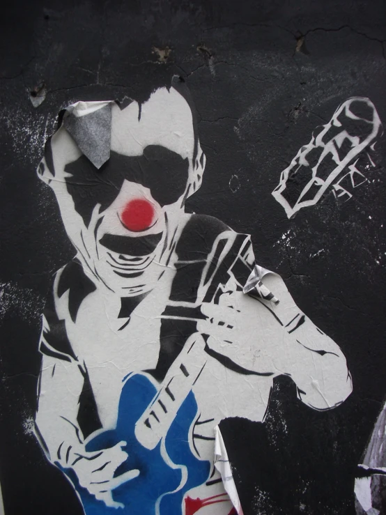 a graffiti painting with a clown holding a blue guitar