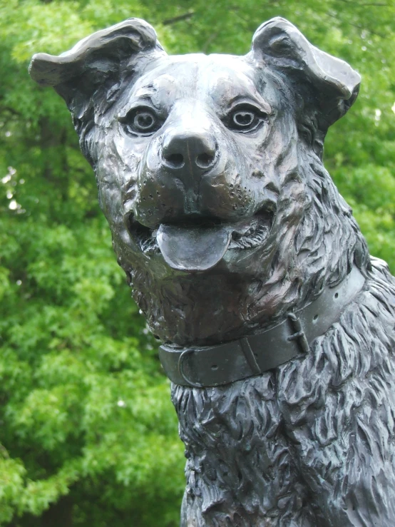 the sculpture of a dog is in front of trees