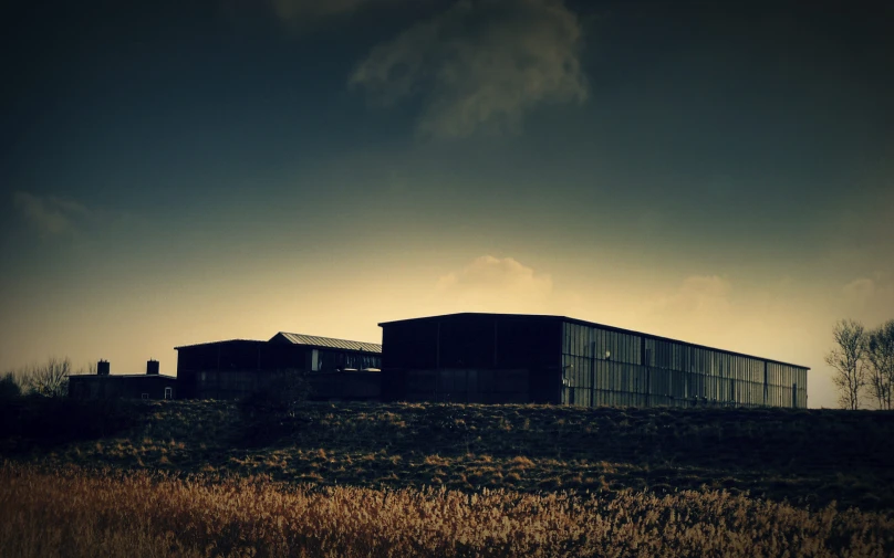 two large buildings sitting on the side of a grass field