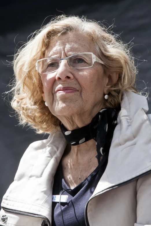 an older woman wearing glasses looking at soing