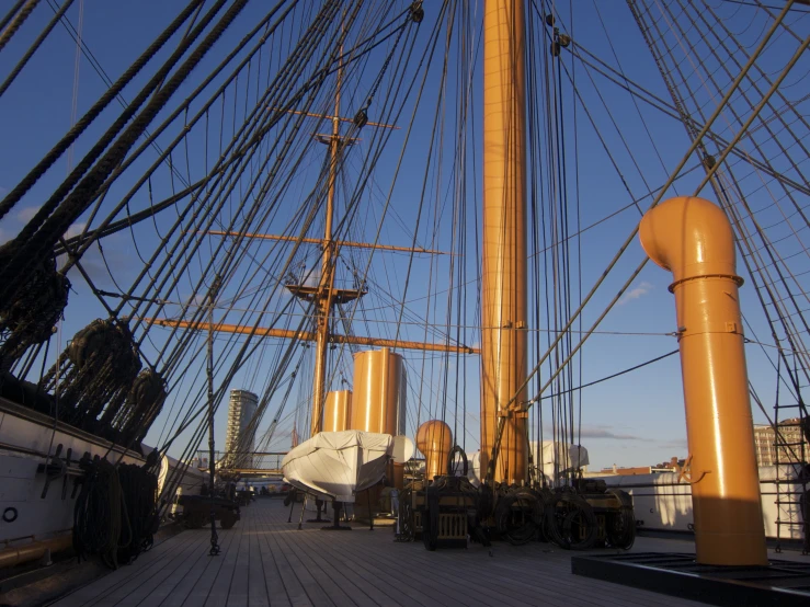 a tall yellow mast on a ship in the ocean