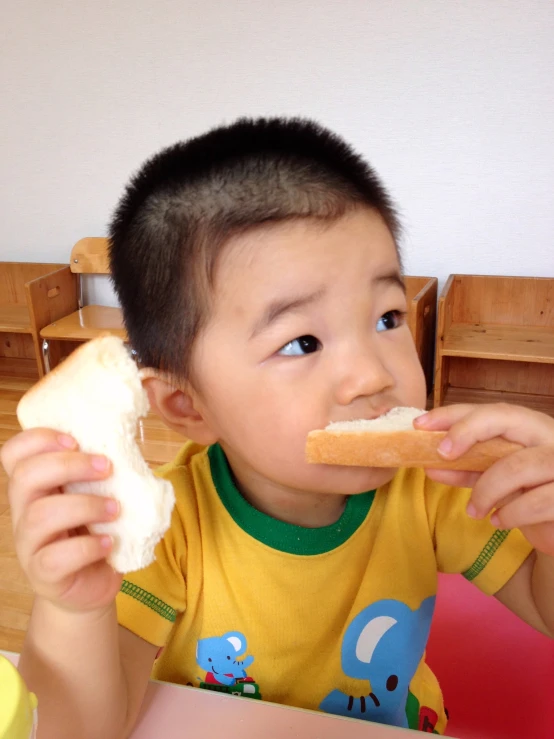 the little boy is enjoying his meal of bread and milk