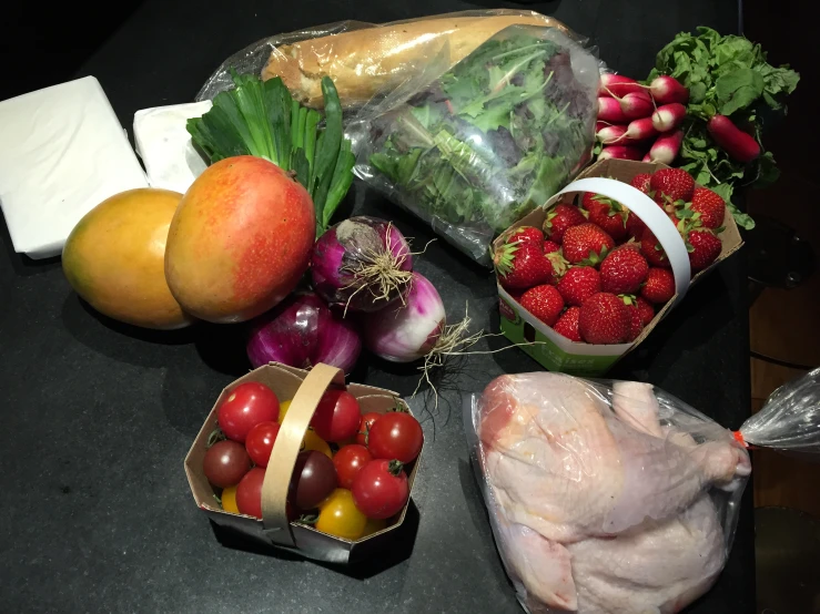 fruits and vegetables on a black table with white wrapping