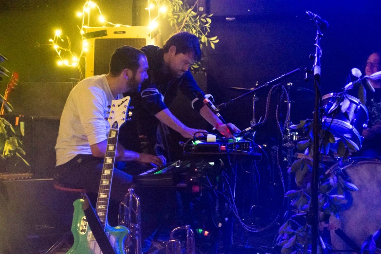 two men are playing some electronic music together