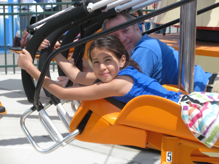 a small girl in the middle of the amut coaster at the theme park