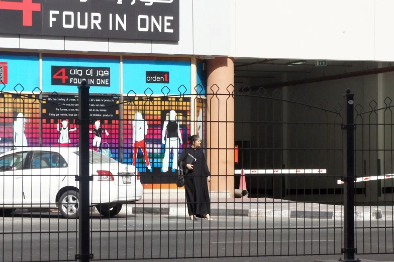 a woman is walking into a building near a fence