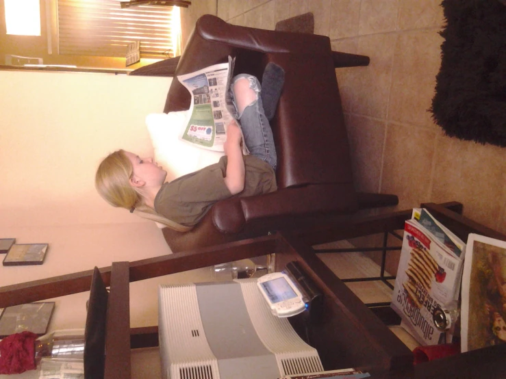 a child is sitting on a brown chair