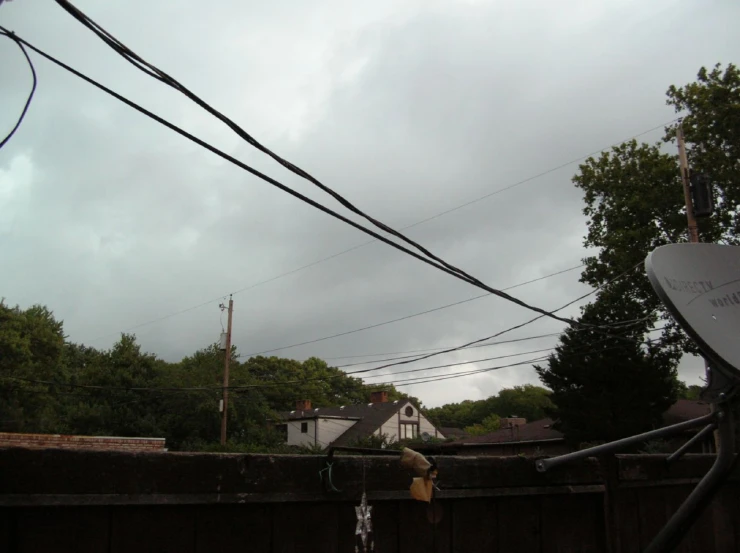 a storm is coming over houses and trees