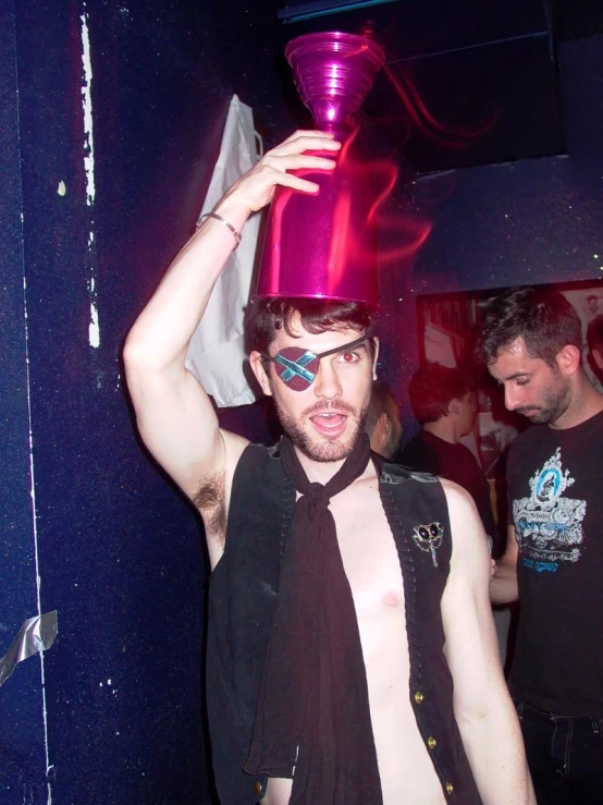 a man standing inside in a room with a silver cup on his head