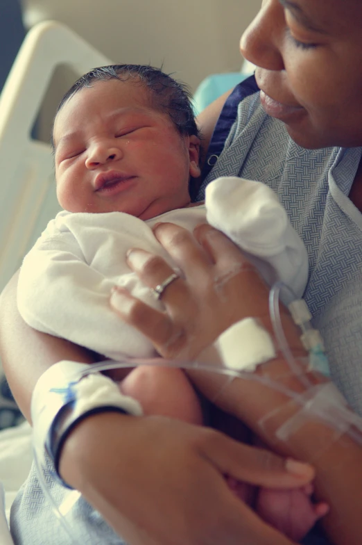 a baby being held in a mother's arms