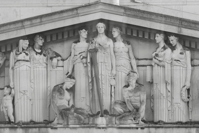 several statues stand next to each other on the side of a building