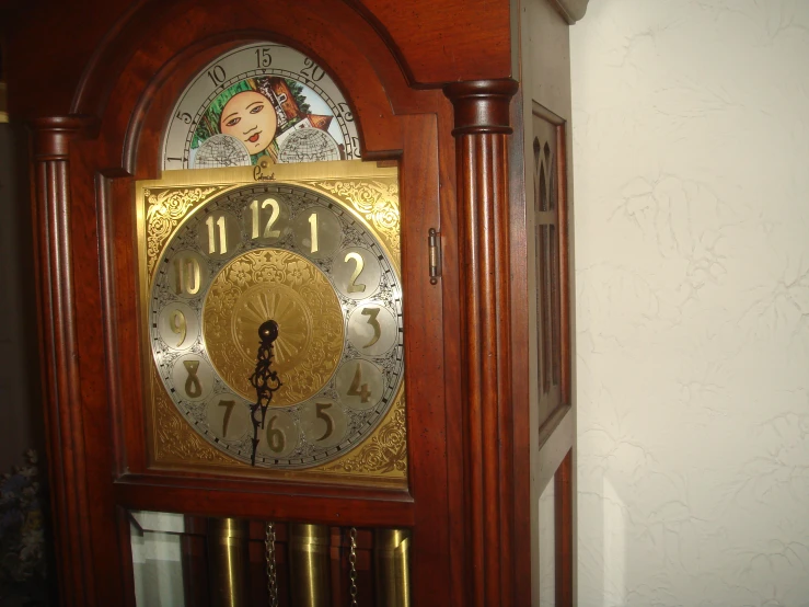 an old grandfather clock has gold dials and decorative decor on it