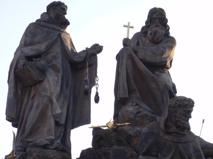 a large stone statue sitting next to a tall cross